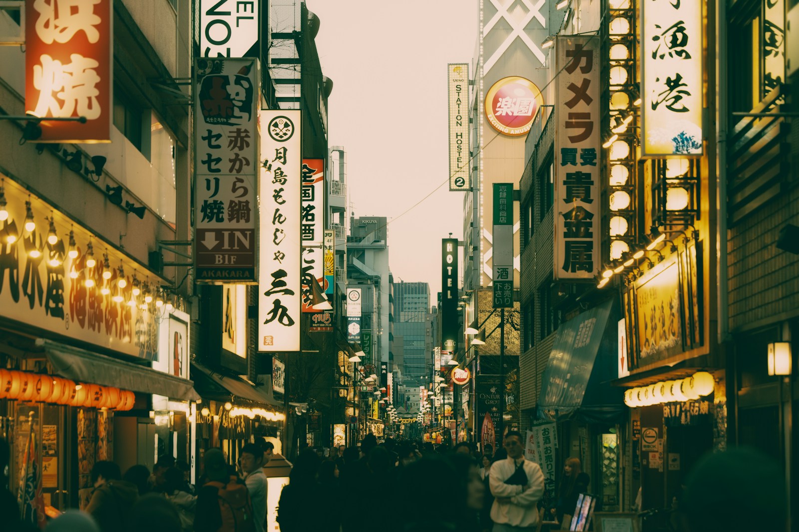 A busy street lined with illuminated signs at dusk.